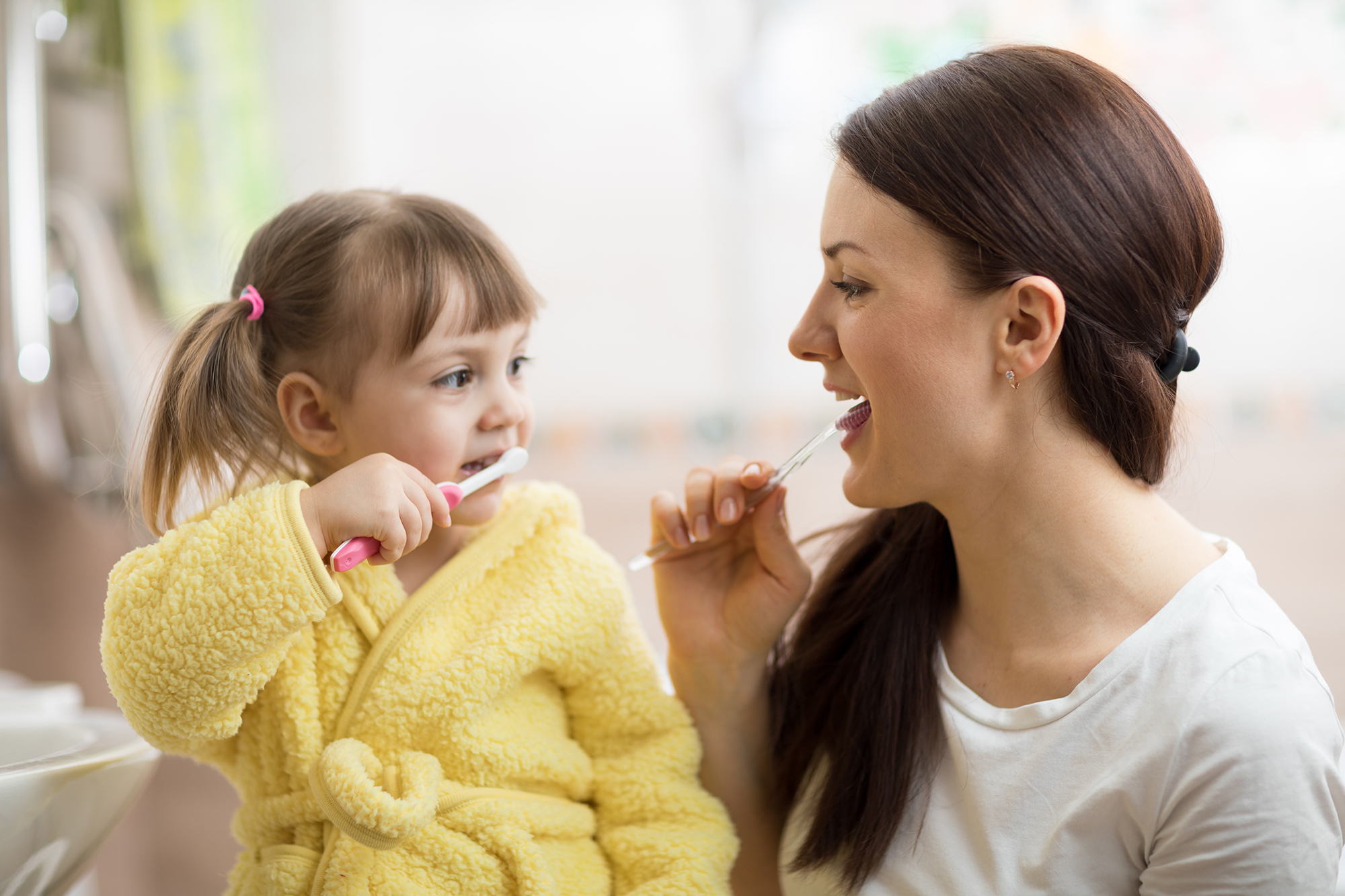 Mother and child brushing teeth