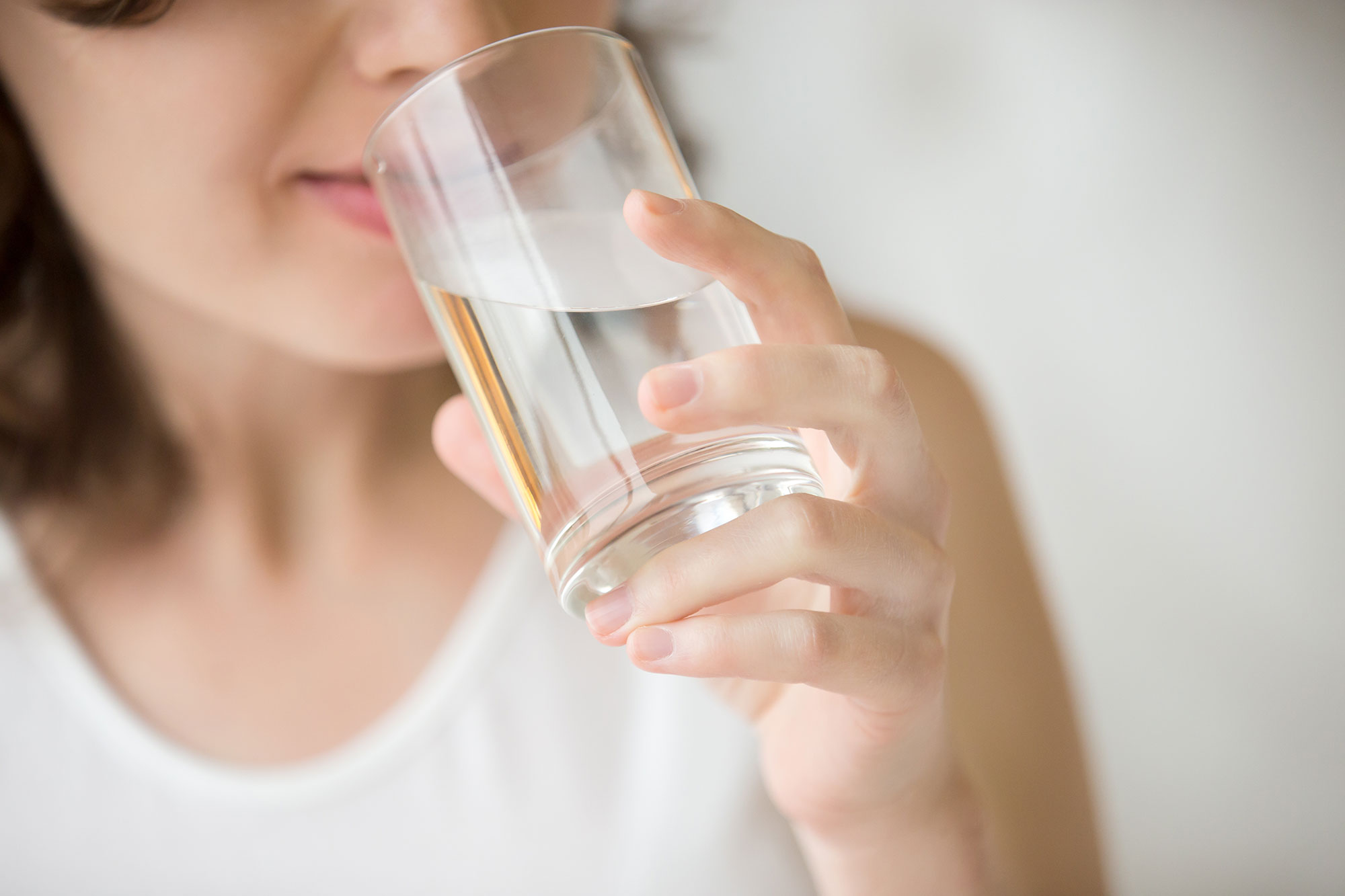 woman drinking water after reading Post-Operative Instructions